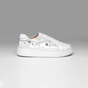 White sneaker with embellishments on a gray background